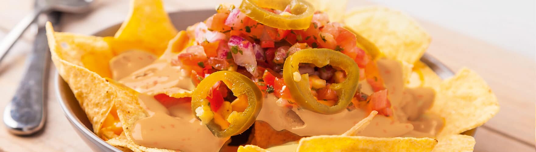 Vegetarische nachoschotel met tomaat, ui en sambal