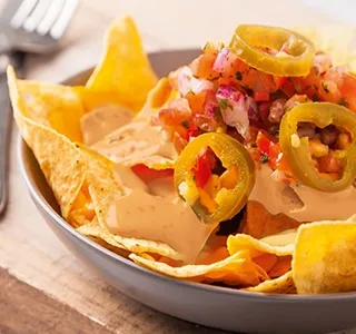Vegetarische nachoschotel met tomaat, ui en sambal