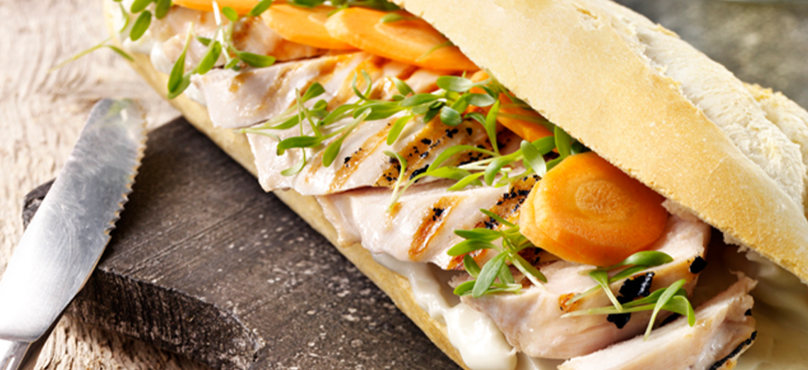 Broodje met gesmolten roquefort, gegrilde kip, wortel en tuinkers