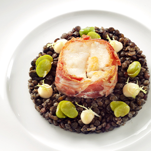 Gebakken zeewolffilet met zwarte linzen en een topping van geitenkaas