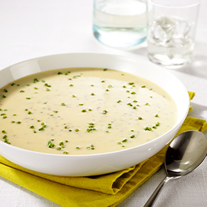 Romige mosterdsoep met een topping van Goudse kaas, ham en bieslook